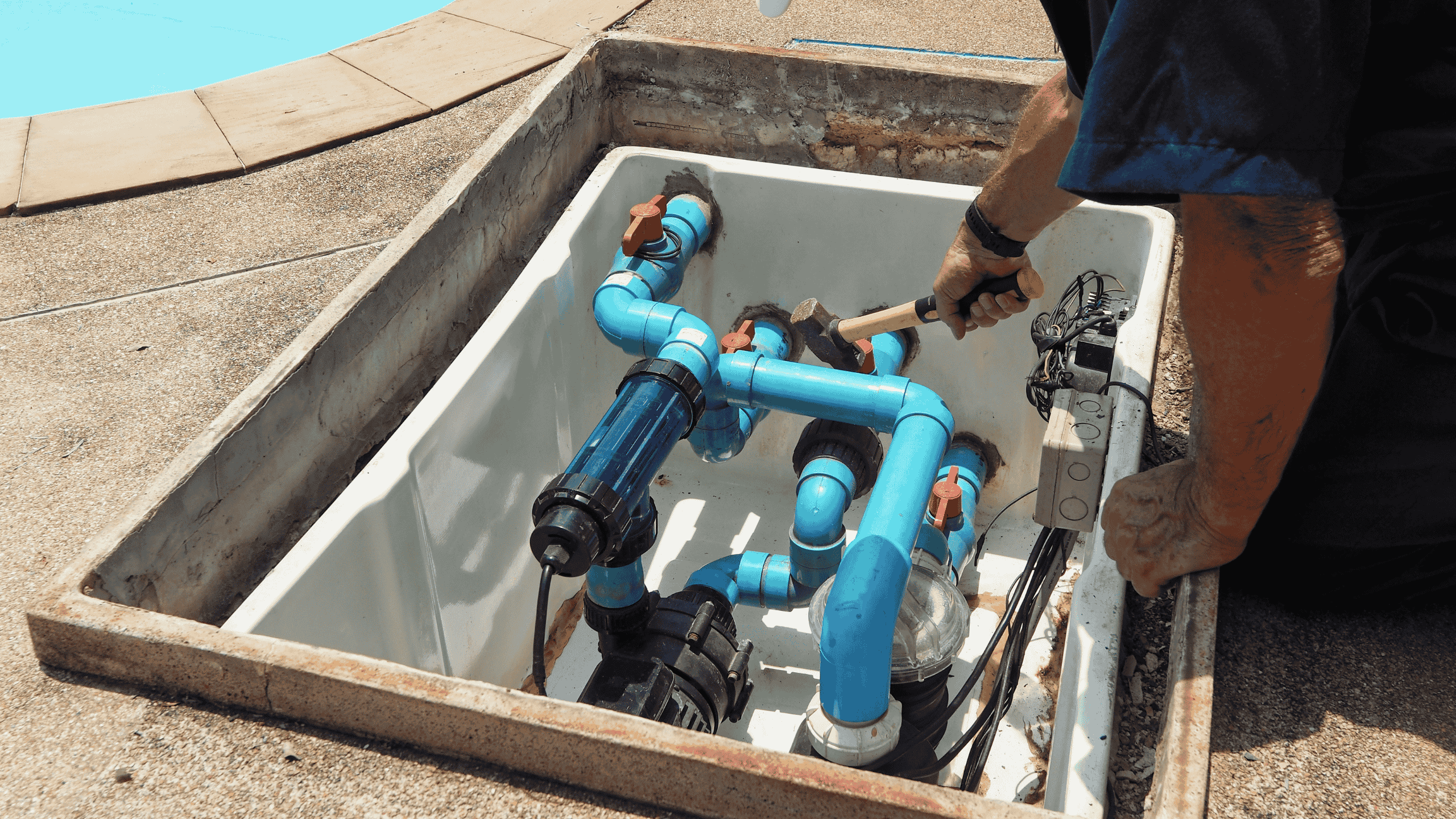 Technician repairing pool equipment near the swimming pool in Los Angeles, CA, provided by Encore Pool Care.